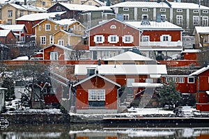 Old historic Porvoo, Finland with Traditional Scandinavian rural red wooden houses under white snow. Snowing