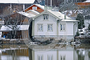 Old historic Porvoo, Finland with Traditional Scandinavian rural red wooden houses under white snow. Snowing