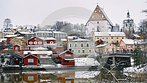 Old historic Porvoo, Finland with wooden houses and medieval stone and brick Porvoo Cathedral under white snow in winter