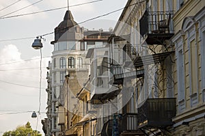 Old historic stone house on the yard with trees around. Old city buildings before and after restavration. Ancient windows, roofs, photo