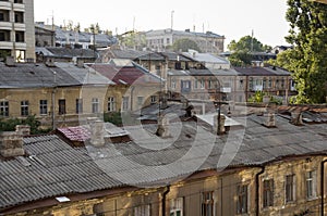 Old historic stone house on the yard with trees around. Old city buildings before and after restavration. Ancient windows, roofs, photo