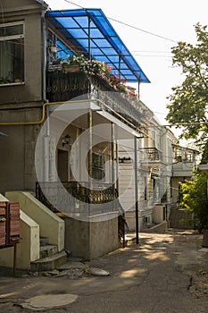 Old historic stone house on the yard with trees around. Old city buildings before and after restavration. Ancient windows, roofs, photo