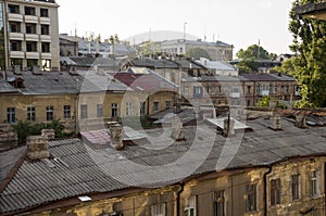 Old historic stone house on the yard with trees around. Old city buildings before and after restavration. Ancient windows, roofs, photo