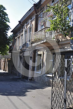 Old historic stone house on the yard with trees around. Old city buildings before and after restavration. Ancient windows, roofs, photo