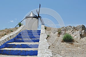 Old historic windmill on the hill of Consuegra, Spain. Whitewashed stairs going up to the mill. Scenic photo