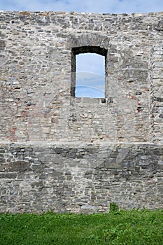 Old, historical and antique wall made of stone.  Facade with window.