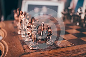 Old historical antique wooden chessboard with brass or copper pieces.