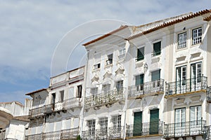 Old historical buildings with shabby facades of white and beige colours downtown Evora, Portugal. Conceptual for protection,