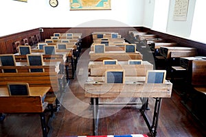 Old historical classroom with wooden desks and chalkboards