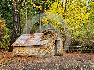 An old historical miner's hut with schicht stone walls and tin roof