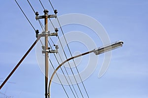 An old, historical power feed line with wires, insulators and a light fitting