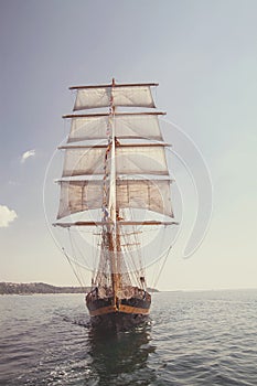 Old historical ship yacht with white sails, sailing in the sea