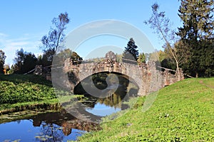 Old historical stone bridge on small river in the forest