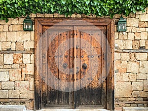 An old historical stone wall with a wooden door gate in Antalya Old town Kaleici, Turkey. Ottoman time architecture. Horizontal