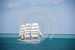 Old historical tall ship with white sails in blue sea russia