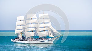 Old historical tall ship with white sails in blue sea russia