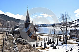 Old Hol Gamle Kyrkje church building stands in the countryside, near a winding road