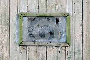 Old hole in Grid on the older green wooden window