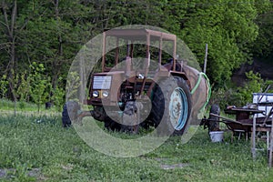 Old homemade rusty tractor with a barrel.