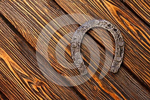 Old rusty horseshoe on vintage wooden board