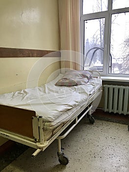 The old hospital from the inside. Filled bed for the nurse on duty in the corridor.