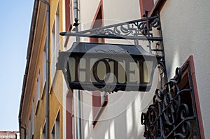 Old hotel sign made of metall on a medieval fascade photo