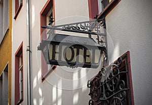 Old hotel sign made of metall on a medieval fascade photo