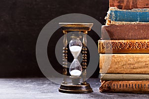 Old hourglass with books