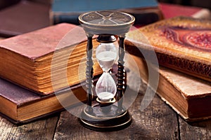 Old hourglass with books