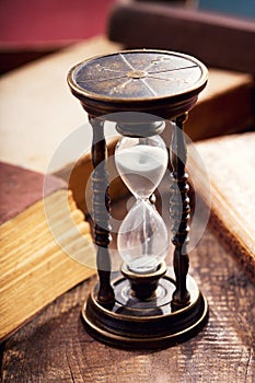 Old hourglass with books