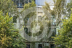 Old house behind a modern glass facade