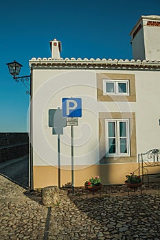 Old house behind a PARKING road sign