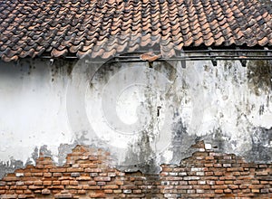 An old house, with broken tiles, demage and vintage brick wall texture for background or wallpaper