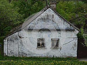 Old house with broken windows and cracked wall