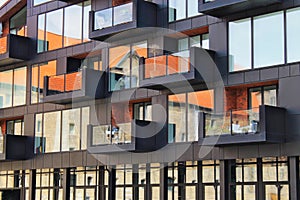 An old house reflected in windows of a new house