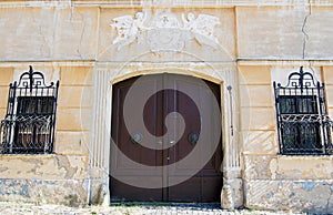 Old house with coat of arms above the wooden gate