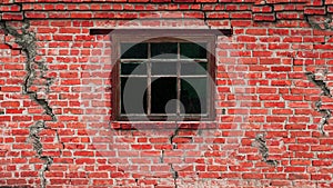 An old house in cracks, a scary wall with a wooden window. Old brick wall with cracks.