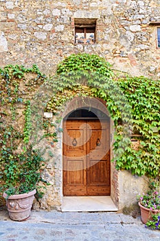 Old house decorated with flowers in Monteriggioni, Tuscany, Italy
