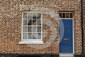 Old House FaÃ§ade with a Wooden Blue Door and Window on brick wall
