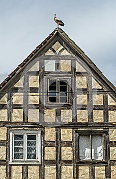 Old house with a half-timbered structure and stork on the roof
