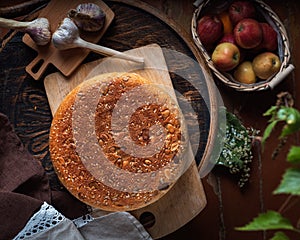 Old house, homemade food. Baked homemade bread, young garlic on a wooden chair, a basket with apples