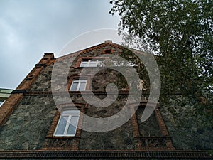 Old house made by stone and brick with window frame without window