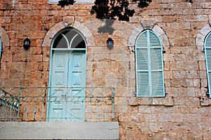 Old house's wall from jerusalem stone with old blue balcony. filtered image