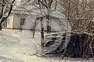 Old house with snowed wattle fence landscape photo