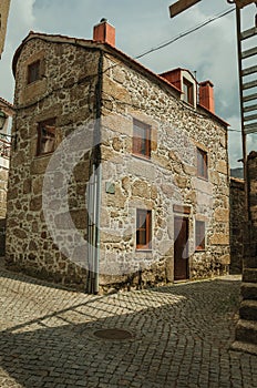 Old house with stone wall in a deserted alley