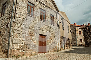 Old house with stone wall in a deserted alley