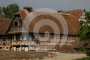 An old house with storck on the roof.