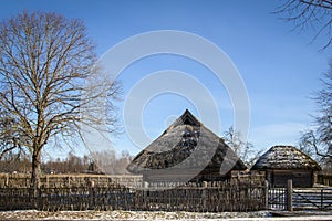 Old house with a straw roof in the blue sky in the spring