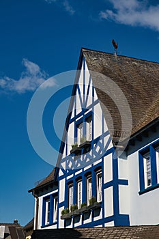 Old house with white and blue trims, featuring a charming balcony window, Rudesheim, Germany