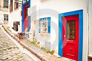 Old house white wall with blue and red door